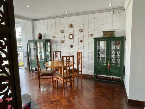 a dining room with a table and chairs and green cabinets at Vintage Apt in the Heart of Ovalo Gutierrez in Lima