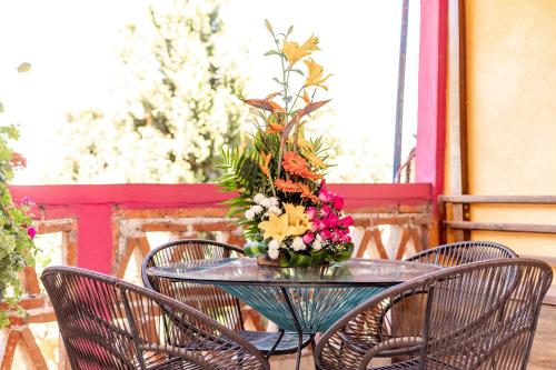 une table en verre avec un vase de fleurs sur elle dans l'établissement El Jazmin de Zanya, à Dolores Hidalgo