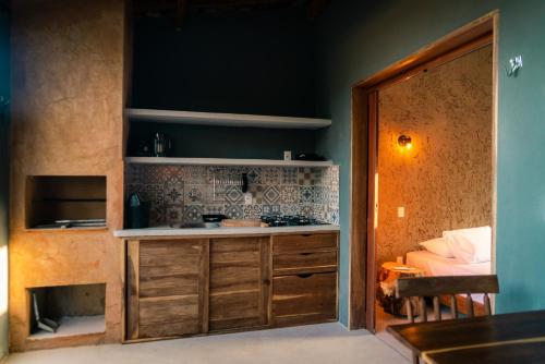 a kitchen with a counter and a stove in a room at Magaral Corais Chalé in Pôrto de Pedras