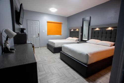 Cette chambre comprend 2 lits et un miroir. dans l'établissement 653 Hotel, à San Luis Río Colorado