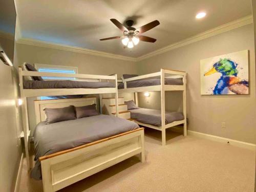 a bedroom with bunk beds and a ceiling fan at Drake on the Lake - False River, LA 
