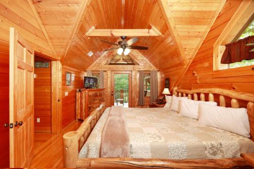 a bedroom in a log cabin with a bed and a ceiling at Thunder Mountain in Sevierville