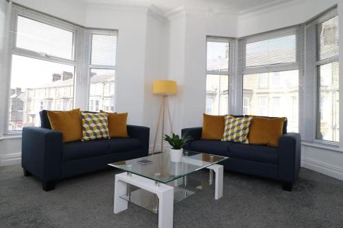 a living room with two blue couches and a coffee table at Ideal Base for Contractors in Central Morecambe- 3 Double Bedrooms in Morecambe