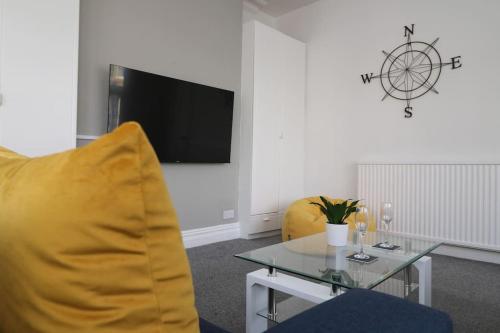 a living room with a table and a yellow chair at Modern 3 Double Bedroom Town Centre Maisonette in Morecambe