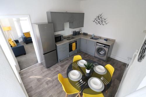 a kitchen and dining room with a table and yellow chairs at Ideal Base for Contractors in Central Morecambe- 3 Double Bedrooms in Morecambe