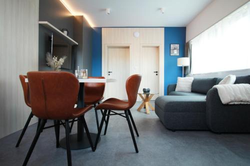 - un salon avec une table, des chaises et un canapé dans l'établissement Apartmán A2 - Hrabovo, à Ružomberok