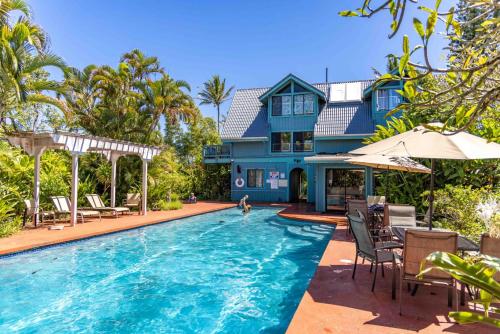 a house with a swimming pool in front of a house at Gardenia Room on Tropical Lush Farm in Haiku, Maui in Huelo