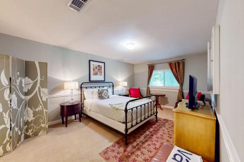 a bedroom with a bed and a tv in it at Family-Friendly City Living in Houston