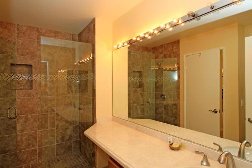 uma casa de banho com um chuveiro, um lavatório e um espelho. em VS555 - Palm Views em Palm Desert