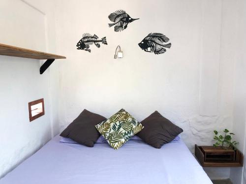a bedroom with a bed with black and white pillows at Una Posada Mas in Mazunte