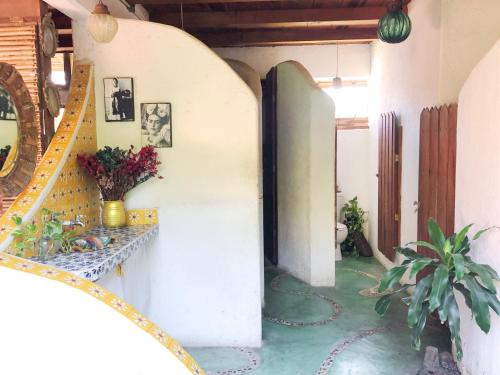 a hallway with a staircase in a house with flowers at Una Posada Mas in Mazunte