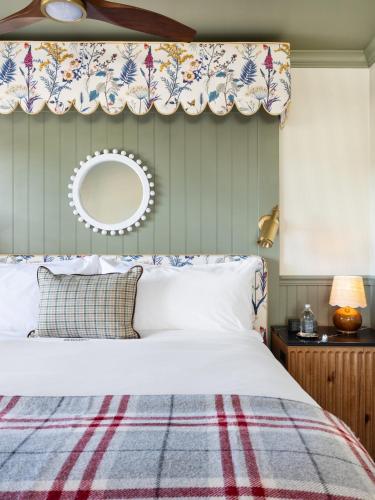 a bedroom with a white bed with a blue and red blanket at Le Petit Pali at 8th Ave in Carmel