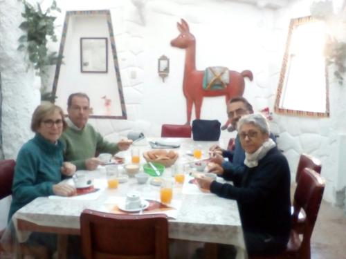 un grupo de personas sentadas en una mesa comiendo en Wulzer Samana Wasi Andahuaylillas, en Andahuaylillas