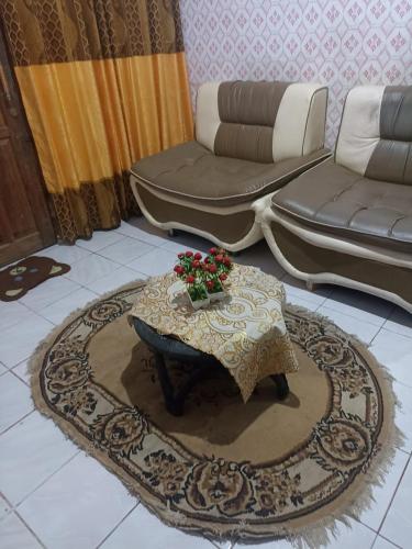 uma sala de estar com uma mesa e um sofá em Regita Homestay Kaledupa em Kaledupa