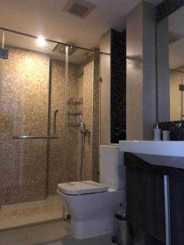 a bathroom with a shower and a toilet and a sink at Central Pattaya Apartments in Pattaya