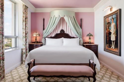 a bedroom with a large bed with a canopy at Grand Galvez Resort, Autograph Collection in Galveston