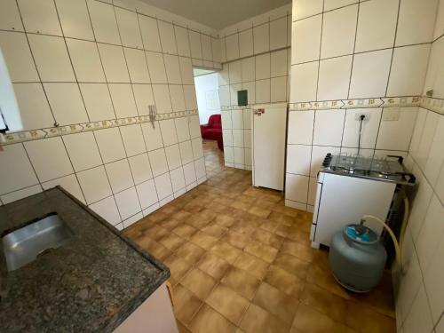 uma pequena casa de banho com um lavatório e um pequeno frigorífico em Pé na areia praia da Guilhermina II na Praia Grande