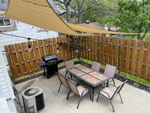 a patio with a table and chairs and a grill at Historic 2 bedroom house St Charles in St. Charles