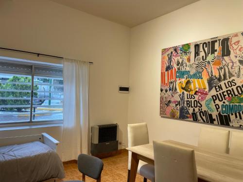 a bedroom with a bed and a table and a painting at Patagonia Apartment in Trelew