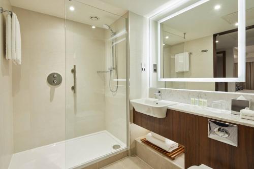 a bathroom with a shower and a sink and a mirror at Courtyard by Marriott Oxford City Centre in Oxford