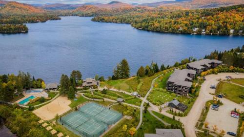 an aerial view of a house with a tennis court on a lake at Deluxe Suite-sur-Lac Superieur - Tremblant Versant Nord in Lac-Superieur