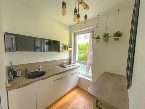 une cuisine avec un évier et une fenêtre dans l'établissement Splendid modern Duplex with 4 bedrooms, very close to Paris, metro 