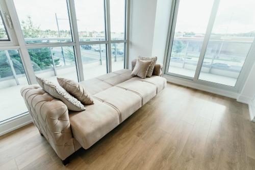 a couch in a large room with windows at Cozy & Contemporary Suite - Easy Access to Everything in Richmond Hill