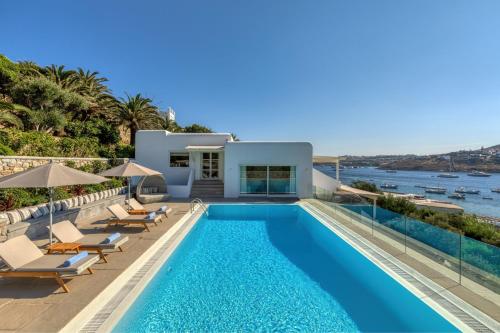 a villa with a swimming pool and a house at Santa Marina, A Luxury Collection Resort, Mykonos in Ornos