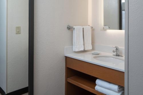 a bathroom with a sink and a mirror and towels at SpringHill Suites by Marriott Charleston Riverview in Charleston