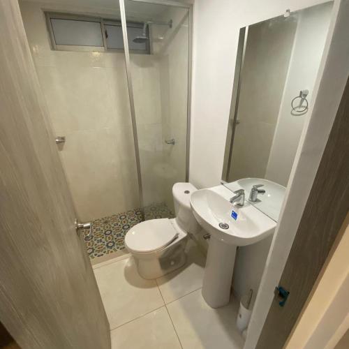 a bathroom with a toilet and a sink and a shower at Aparta Suites Balcones de la Sierra in Fundación