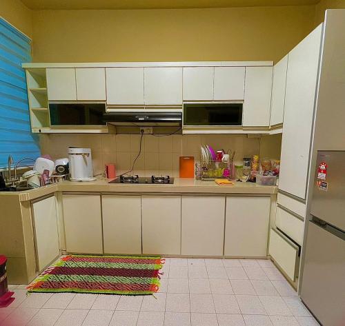 a kitchen with white cabinets and a counter top at Homestay FourSeasons @ Bandar Baru Bangi in Bandar Baru Bangi