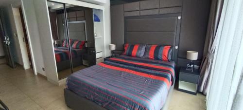 a bedroom with a bed with a red and blue blanket at Central Pattaya Apartments in Pattaya