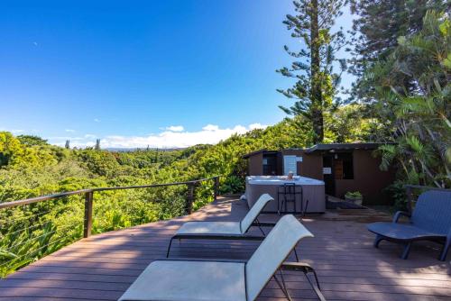 a deck with benches and a table and chairs at Plumeria Room on a Lush Farm on Maui's North Shore in Huelo