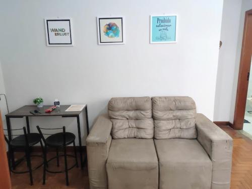 a living room with a couch and a table at Apartamento completo no centro in Teresópolis