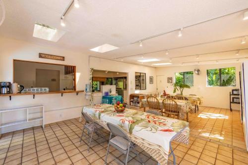a kitchen and a dining room with a table at Plumeria Room on a Lush Farm on Maui's North Shore in Huelo