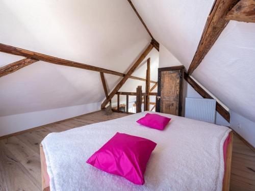 um quarto com uma cama branca e almofadas cor-de-rosa em Comfy holiday home in Roes with terrace em Roes