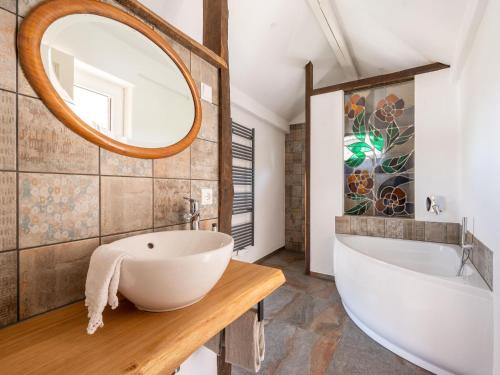 a bathroom with a white tub and a large mirror at Comfy holiday home in Roes with terrace in Roes