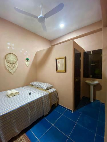 a bedroom with a bed with a blue floor at Casa Lol-cab Hostal in Valladolid