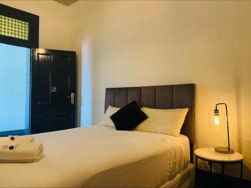 a bedroom with a large white bed with a black headboard at Belmore Hotel Scone in Scone