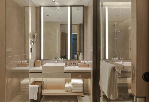 a bathroom with a sink and a large mirror at The Meixi Lake, Changsha Marriott Executive Apartments in Changsha