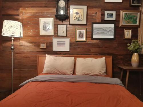 a bedroom with a bed and pictures on the wall at ทุ่งยั้งเฮ้าส์ in Uttaradit