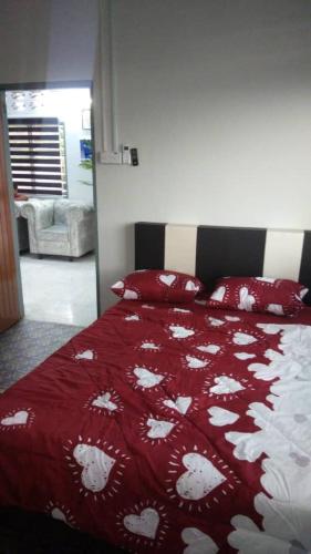 a bedroom with a bed with a red and white blanket at IPOH Homestay in Ipoh