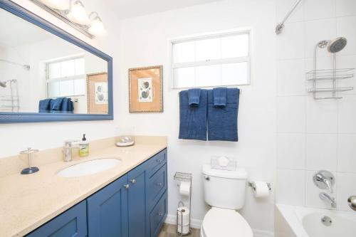 W łazience znajduje się toaleta, umywalka i lustro. w obiekcie Beach Living at Moon Bay with SeaView w mieście Bodden Town