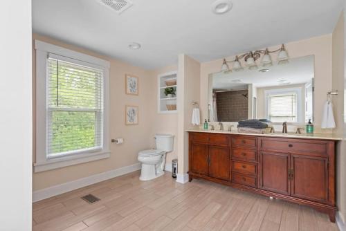 a bathroom with a toilet and a sink and a mirror at 4 Bedroom House, sleeps 12, short walk to Main St! in St. Charles