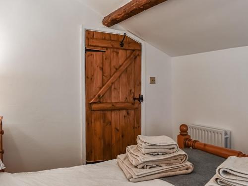 a room with a bed and a wooden door at Greystones in Ravenstonedale