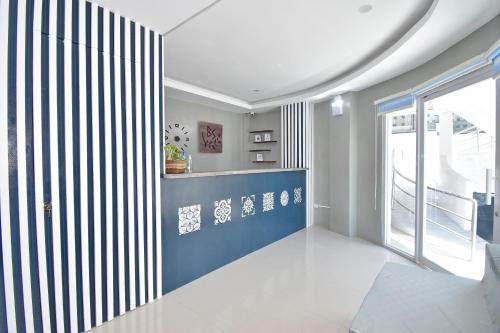 Blue Suites Boracay في بوراكاي: غرفة معيشة بجدار ازرق وابيض