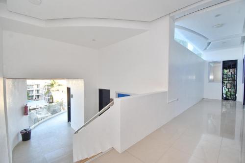 un pasillo abierto con paredes blancas y suelo de baldosa blanca en Blue Suites Boracay en Boracay