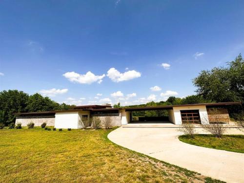 a large white house with a large driveway at Stunning Mid-Cent Modern Retreat • Comfy Beds • Grove • Quiet Setting • Boat Parking in Grove