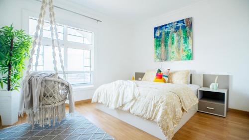 a white bedroom with a bed and a window at Gorgeous Seaview Condo in Gleem in Alexandria