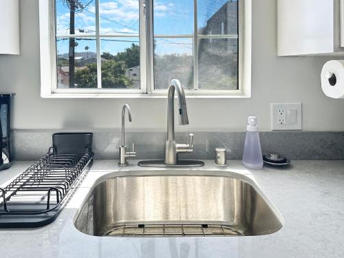a stainless steel sink in a kitchen with two windows at Discount For 30 Days Plus Stay In Culver City in Los Angeles